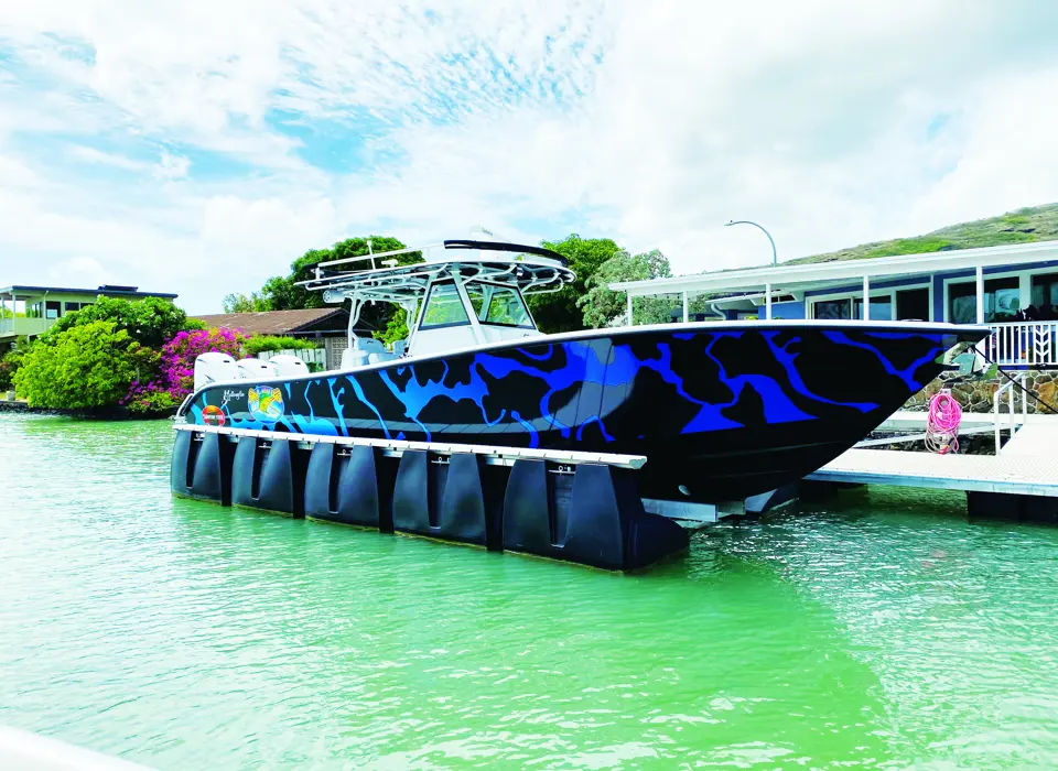 HydroHoist boat lift with blue tanks supporting a boat at the dock